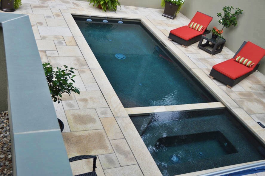 Inspiration for a large modern backyard custom-shaped pool in New York with a hot tub and stamped concrete.
