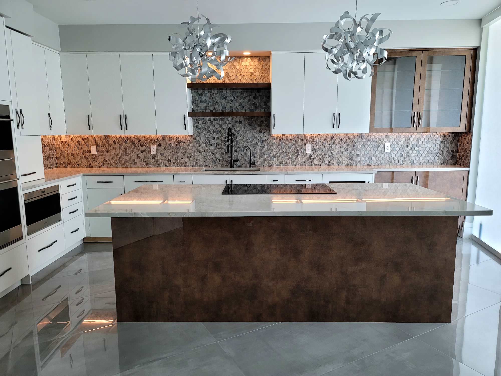 This is a two color custom built wood cabinetry with laminate overlay for that shiny touch and design. Beautiful hexagon backsplash to match the new Quartz countertops.