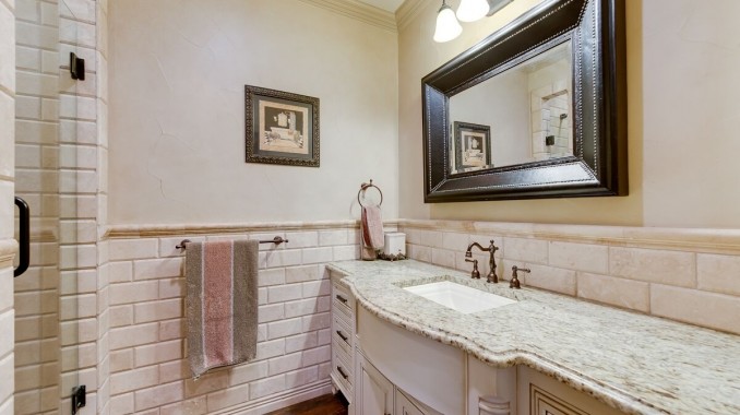 This is an example of a large traditional master bathroom in Dallas with raised-panel cabinets, white cabinets, a drop-in tub, an alcove shower, beige tile, brown tile, porcelain tile, beige walls, dark hardwood floors, an undermount sink, granite benchtops, brown floor and a hinged shower door.