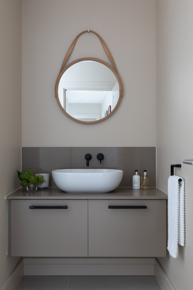 Photo of a small contemporary powder room in Hertfordshire with quartzite benchtops, flat-panel cabinets, grey cabinets, grey walls, a vessel sink, grey floor and grey benchtops.