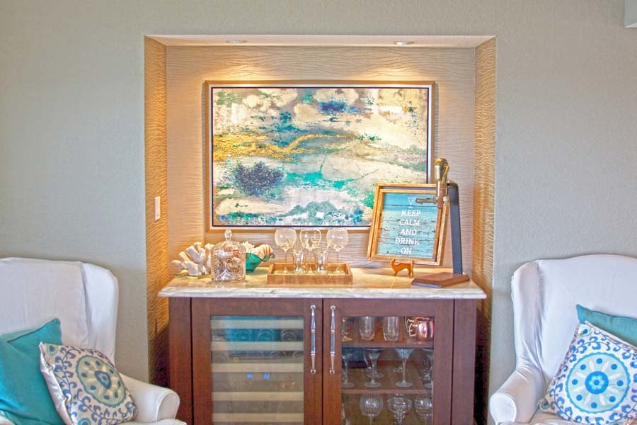 Inspiration for a small beach style single-wall wet bar in Orlando with no sink, glass-front cabinets, medium wood cabinets, marble benchtops and light hardwood floors.