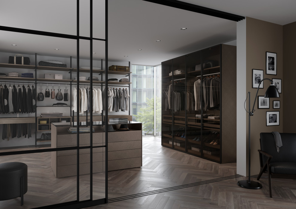 Photo of an expansive contemporary gender-neutral walk-in wardrobe in Cologne with glass-front cabinets, dark wood cabinets, dark hardwood floors, brown floor and wallpaper.