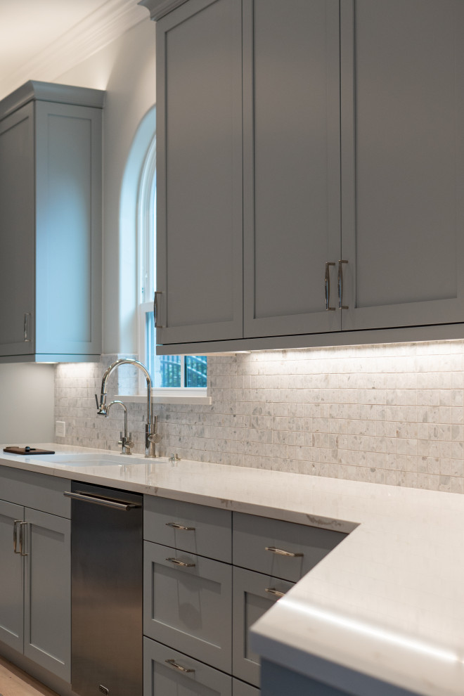 Large transitional u-shaped light wood floor and beige floor eat-in kitchen photo in Houston with an undermount sink, shaker cabinets, gray cabinets, quartz countertops, ceramic backsplash, stainless steel appliances and white countertops