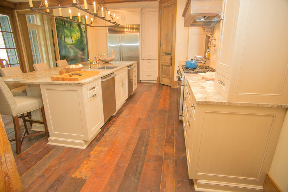 Photo of a large country l-shaped kitchen in New Orleans with a single-bowl sink, recessed-panel cabinets, distressed cabinets, marble benchtops, stainless steel appliances, dark hardwood floors and with island.