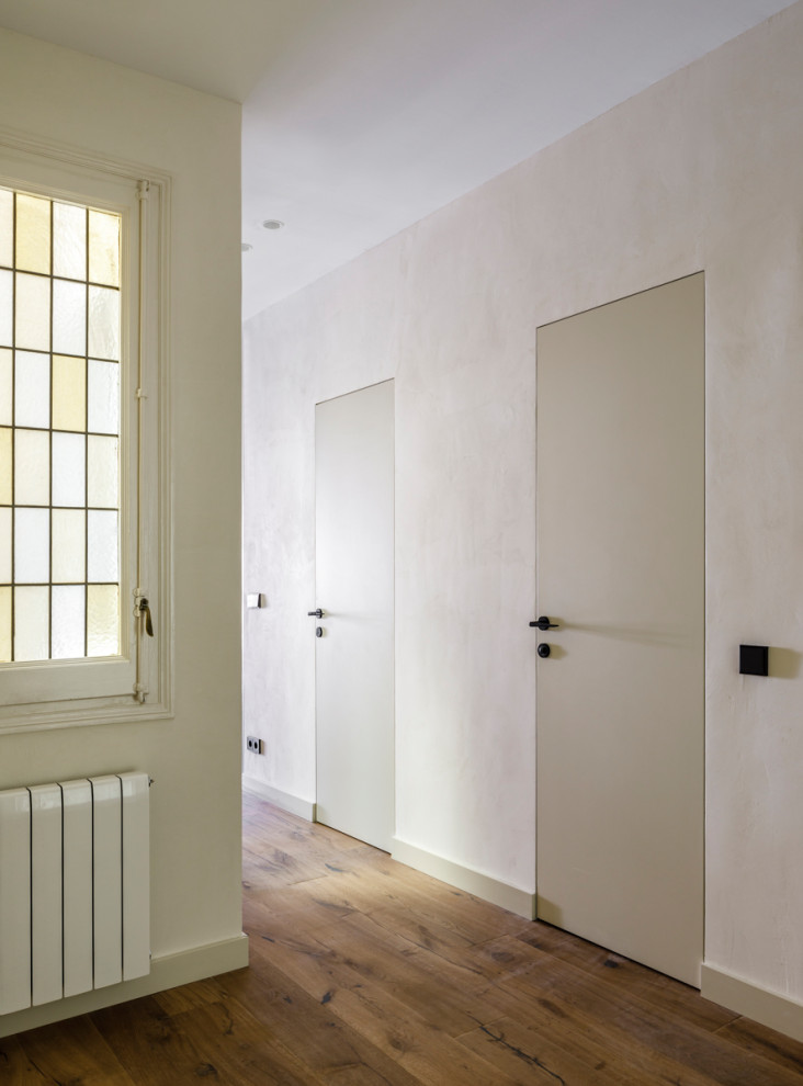 Immagine di un ingresso o corridoio moderno di medie dimensioni con pareti beige, pavimento in laminato e pavimento marrone
