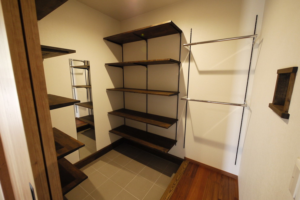 Imagen de armario vestidor unisex de estilo zen con armarios abiertos, suelo de baldosas de porcelana y suelo gris