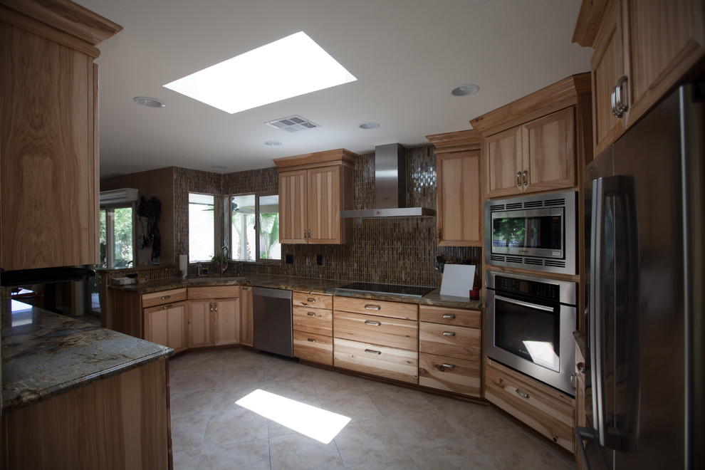 Example of a large transitional galley ceramic tile enclosed kitchen design in Phoenix with an undermount sink, recessed-panel cabinets, light wood cabinets, granite countertops, brown backsplash, glass tile backsplash and stainless steel appliances