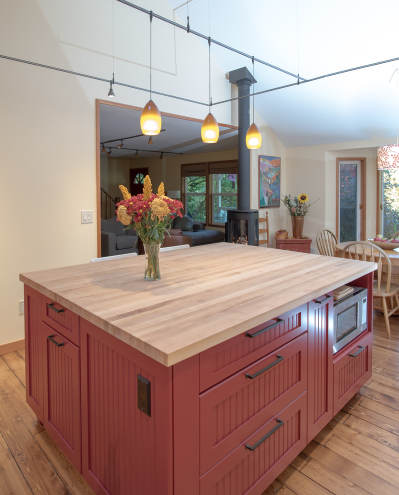 Mid-sized country l-shaped eat-in kitchen in Seattle with a farmhouse sink, recessed-panel cabinets, white cabinets, solid surface benchtops, white splashback, ceramic splashback, stainless steel appliances, with island, dark hardwood floors, beige floor and vaulted.