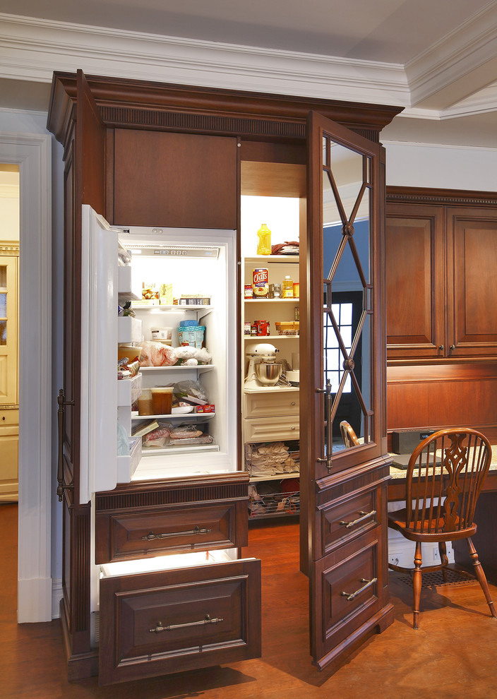 Traditional kitchen in Dallas with raised-panel cabinets and dark wood cabinets.