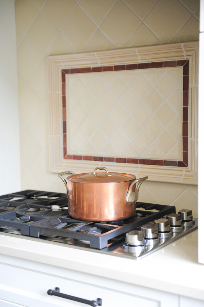 Inspiration for a mid-sized transitional u-shaped dark wood floor home design remodel in Vancouver with an undermount sink, recessed-panel cabinets, white cabinets, wood countertops, beige backsplash, terra-cotta backsplash, stainless steel appliances and an island