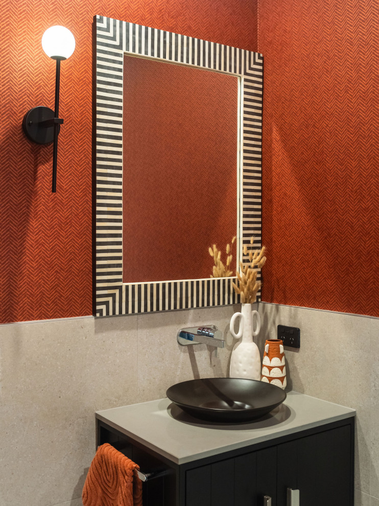 Стильный дизайн: туалет среднего размера в современном стиле с бежевой плиткой, керамогранитной плиткой, оранжевыми стенами, полом из керамогранита, консольной раковиной, столешницей из искусственного кварца, бежевым полом, серой столешницей, напольной тумбой и обоями на стенах - последний тренд