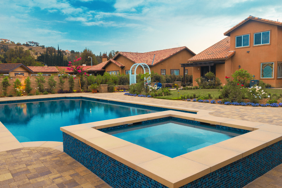 Hot tub - mid-sized rustic backyard concrete paver and custom-shaped natural hot tub idea in Los Angeles