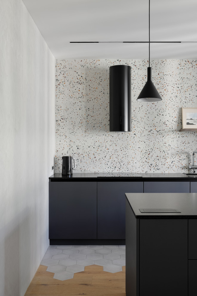 Inspiration for a mid-sized contemporary galley eat-in kitchen in Saint Petersburg with an undermount sink, flat-panel cabinets, grey cabinets, quartz benchtops, multi-coloured splashback, limestone splashback, black appliances, light hardwood floors, with island, beige floor and black benchtop.