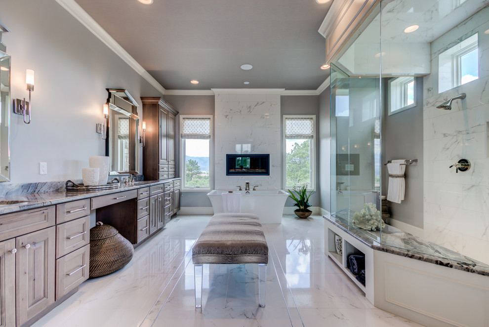 Large traditional master bathroom in Denver with raised-panel cabinets, light wood cabinets, a freestanding tub, a curbless shower, a two-piece toilet, white tile, porcelain tile, grey walls, porcelain floors, an undermount sink, marble benchtops, white floor and an open shower.