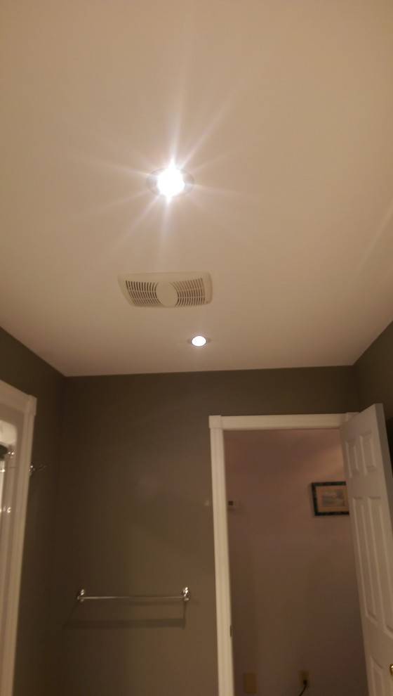 Mid-sized transitional master vinyl floor and multicolored floor alcove bathtub photo with recessed-panel cabinets, medium tone wood cabinets, a two-piece toilet, gray walls, laminate countertops and yellow countertops