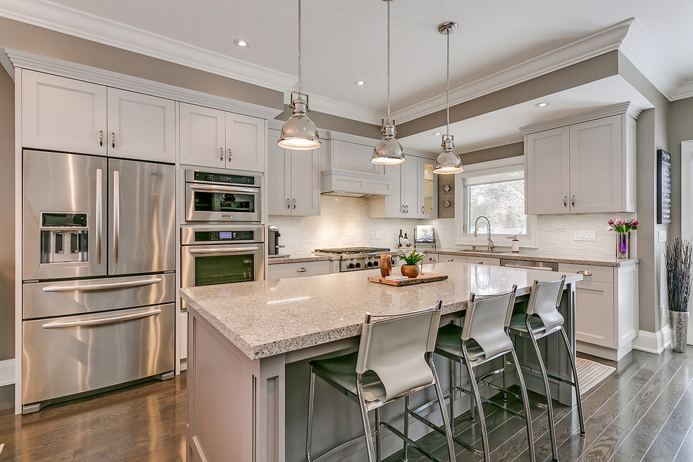 Inspiration for a mid-sized transitional l-shaped open concept kitchen remodel in Toronto with an undermount sink, shaker cabinets, white cabinets, quartz countertops, white backsplash, matchstick tile backsplash, stainless steel appliances, an island and multicolored countertops