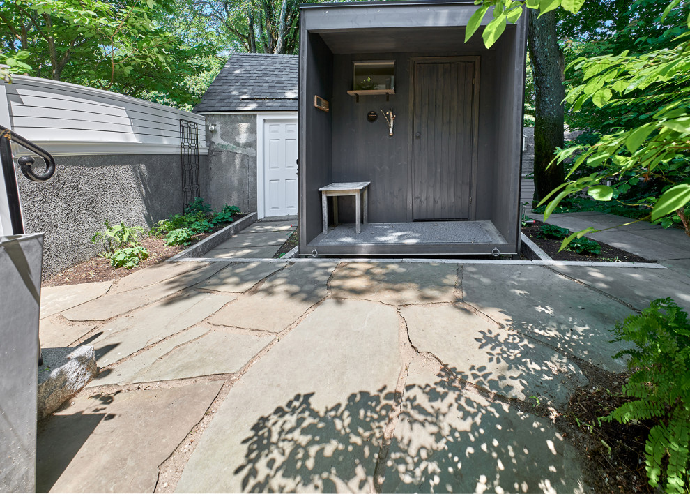 This is an example of a small scandinavian side yard partial sun garden for winter in Boston with with privacy feature and natural stone pavers.