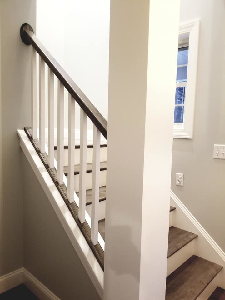 Inspiration for a transitional brown floor staircase remodel with an undermount sink, flat-panel cabinets, white cabinets, quartzite countertops, white backsplash, subway tile backsplash, stainless steel appliances and an island
