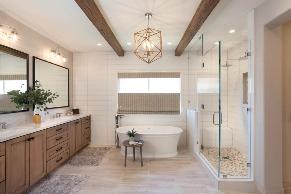 Design ideas for a large beach style master bathroom in Denver with recessed-panel cabinets, beige cabinets, a freestanding tub, an open shower, a two-piece toilet, white tile, ceramic tile, white walls, porcelain floors, an undermount sink, engineered quartz benchtops, beige floor, a hinged shower door and white benchtops.