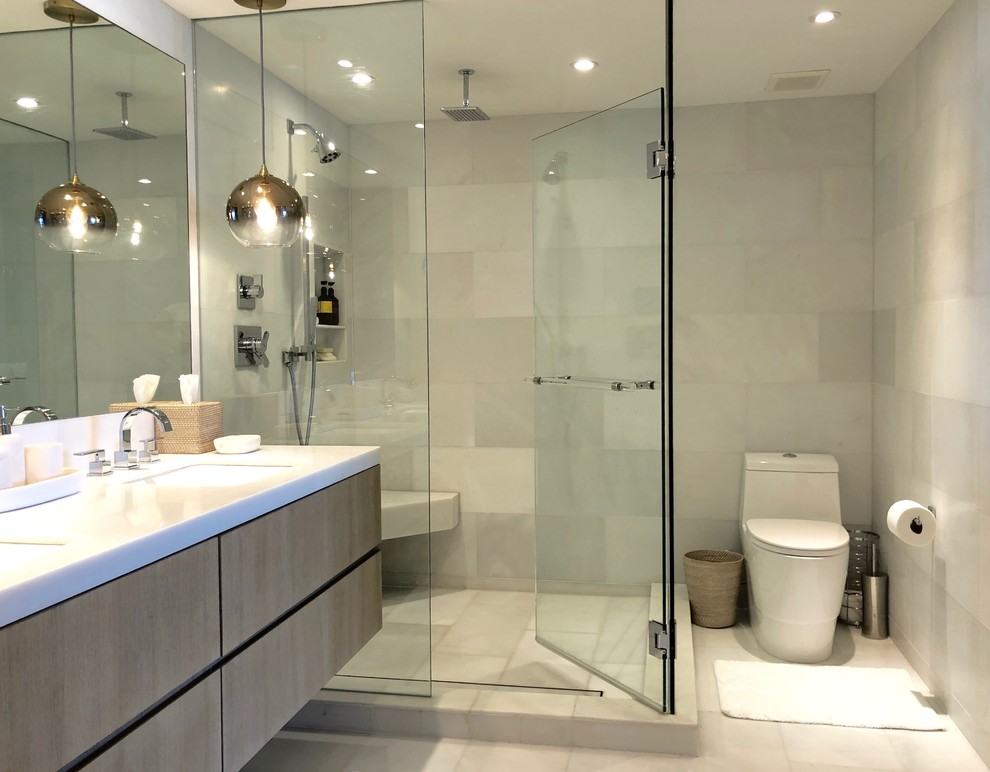 Inspiration for a mid-sized modern master bathroom in Miami with flat-panel cabinets, distressed cabinets, an undermount tub, a corner shower, a one-piece toilet, white tile, ceramic tile, white walls, marble floors, a wall-mount sink, wood benchtops, white floor and a hinged shower door.