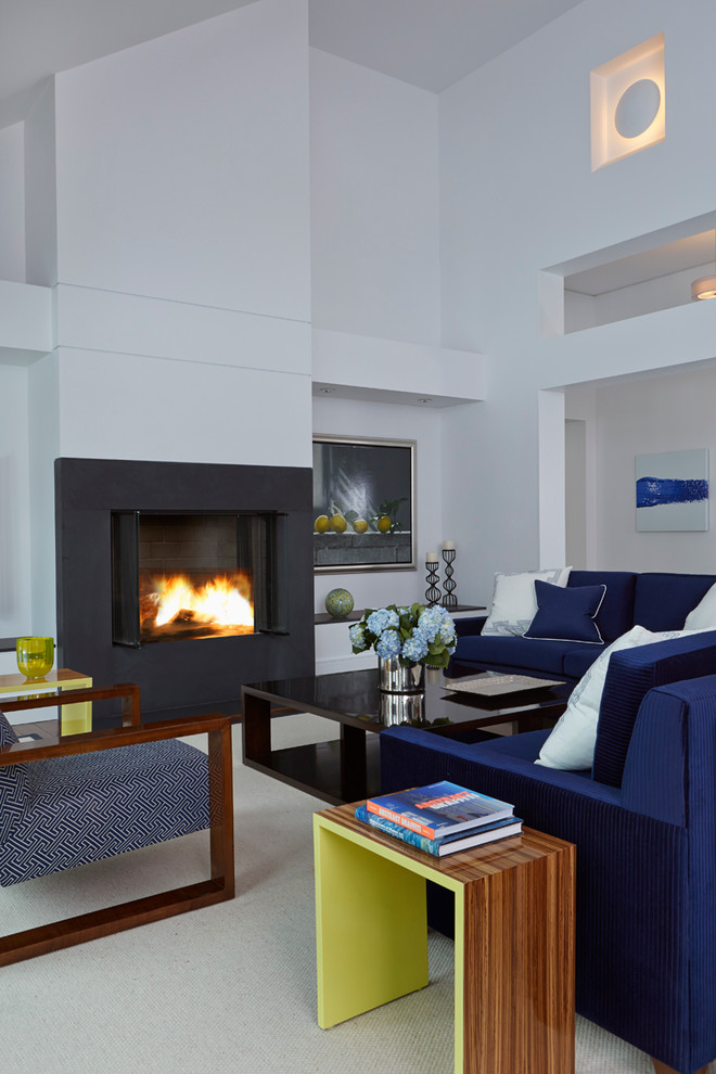 Photo of a contemporary open concept living room in New York with white walls and a metal fireplace surround.
