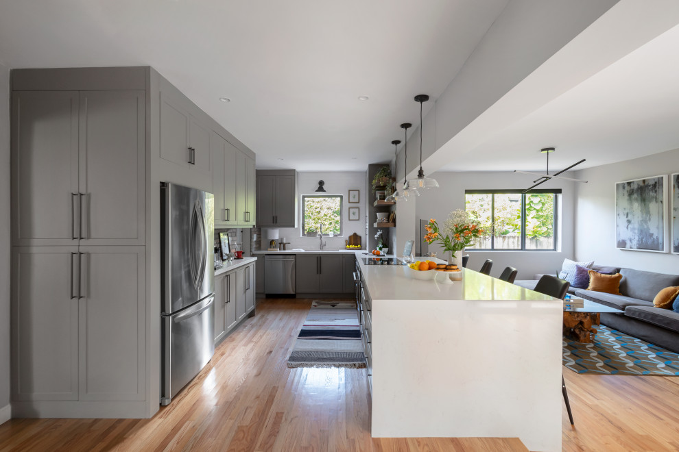 Eat-in kitchen - mid-sized transitional galley medium tone wood floor eat-in kitchen idea in Miami with an undermount sink, shaker cabinets, gray cabinets, quartz countertops, white backsplash, subway tile backsplash, stainless steel appliances, a peninsula and white countertops