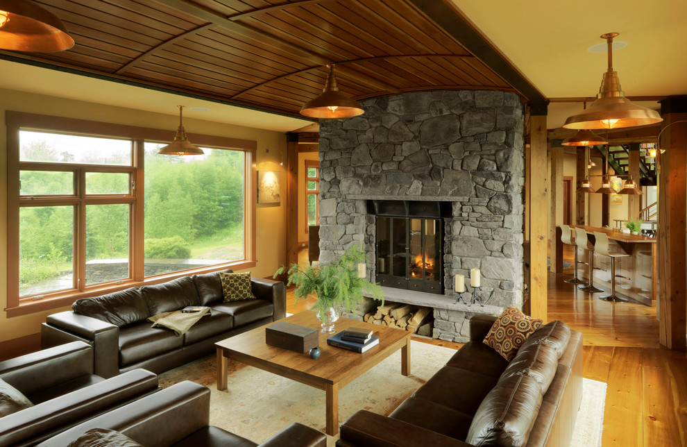 This is an example of a mid-sized country formal enclosed living room in Burlington with yellow walls, medium hardwood floors, a stone fireplace surround, brown floor, a two-sided fireplace and no tv.