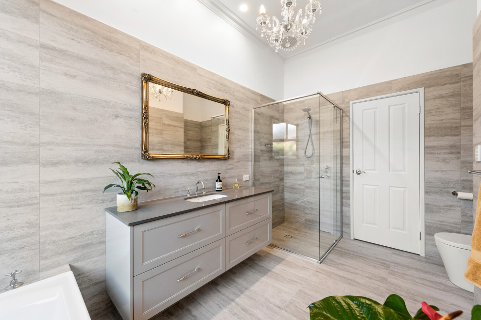 Large traditional master bathroom in Perth with recessed-panel cabinets, grey cabinets, a drop-in tub, a corner shower, gray tile, grey walls, an undermount sink, grey floor, a hinged shower door, grey benchtops, a single vanity and a built-in vanity.