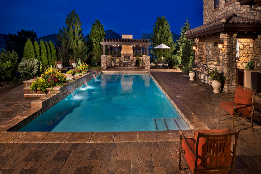 Mediterranean rectangular pool in Denver with natural stone pavers.