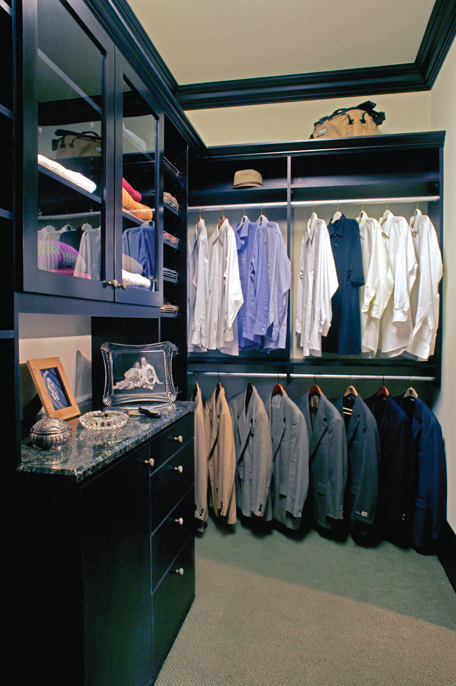 Inspiration for a modern men's walk-in wardrobe in Philadelphia with glass-front cabinets, black cabinets and carpet.