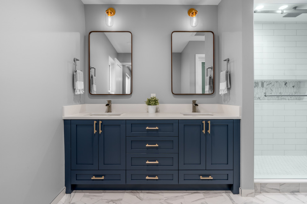 This is an example of a mid-sized transitional master bathroom in Vancouver with shaker cabinets, blue cabinets, a double shower, a one-piece toilet, white tile, subway tile, grey walls, porcelain floors, an undermount sink, engineered quartz benchtops, grey floor, a sliding shower screen and white benchtops.