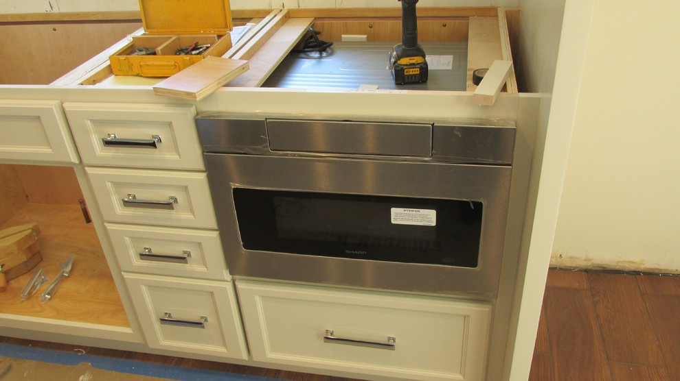 Inspiration for a large transitional ceramic tile kitchen remodel with an undermount sink, recessed-panel cabinets, white cabinets, quartzite countertops, gray backsplash, subway tile backsplash, stainless steel appliances and an island