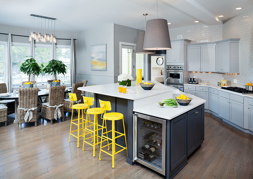 This is an example of a large beach style u-shaped kitchen in New York with a farmhouse sink, shaker cabinets, grey cabinets, quartzite benchtops, grey splashback, subway tile splashback, stainless steel appliances, medium hardwood floors, with island, grey floor and white benchtop.