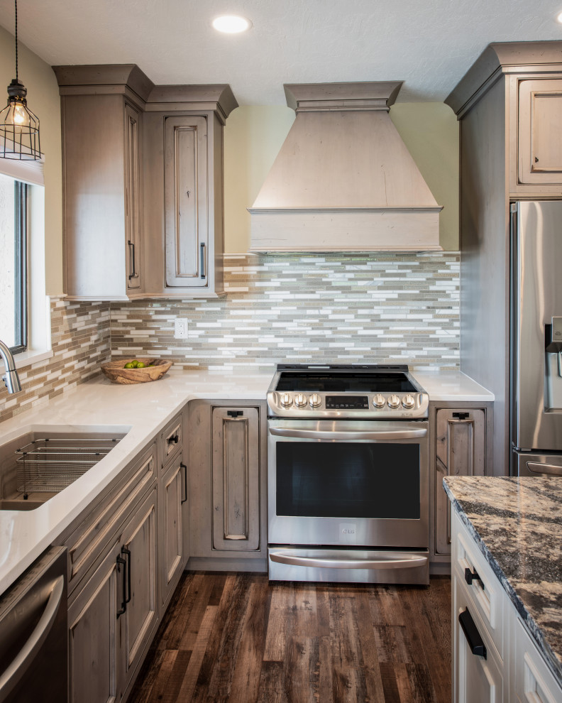 Example of a large mountain style l-shaped brown floor eat-in kitchen design in Orlando with an undermount sink, recessed-panel cabinets, distressed cabinets, quartz countertops, multicolored backsplash, mosaic tile backsplash, stainless steel appliances, an island and white countertops