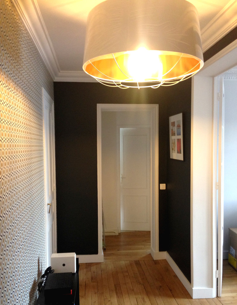 Inspiration for a mid-sized eclectic foyer in Paris with black walls, light hardwood floors and a double front door.