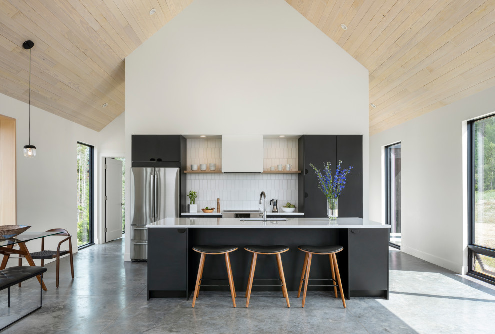 This is an example of a scandi kitchen in Denver with a submerged sink, flat-panel cabinets, black cabinets, engineered stone countertops, white splashback, ceramic splashback, stainless steel appliances, concrete flooring, grey floors, white worktops and a vaulted ceiling.
