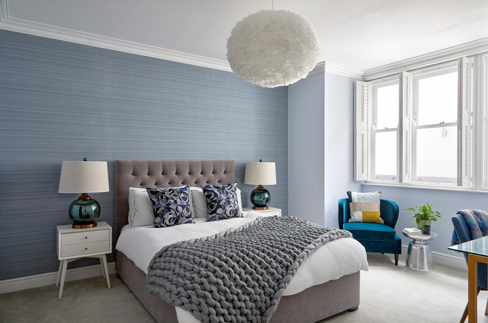 This is an example of a mid-sized transitional guest bedroom in London with blue walls, carpet, no fireplace and grey floor.