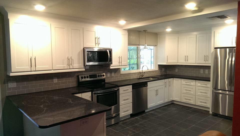 Eat-in kitchen - mid-sized transitional u-shaped ceramic tile and black floor eat-in kitchen idea in Miami with shaker cabinets, white cabinets, laminate countertops, gray backsplash, stainless steel appliances, a peninsula, an undermount sink, subway tile backsplash and black countertops