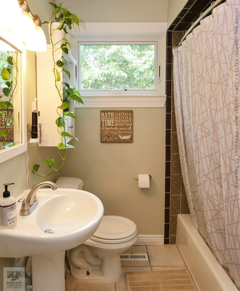 This is an example of a mid-sized bathroom in New York with an alcove tub, a shower/bathtub combo, a two-piece toilet, brown tile, ceramic tile, beige walls, brick floors, a pedestal sink, beige floor, a shower curtain, a single vanity, a built-in vanity and vaulted.