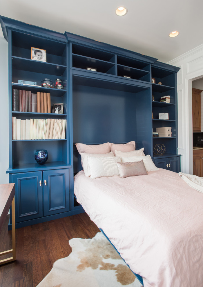 Photo of a mid-sized transitional gender-neutral storage and wardrobe in Denver with recessed-panel cabinets, blue cabinets, laminate floors and brown floor.