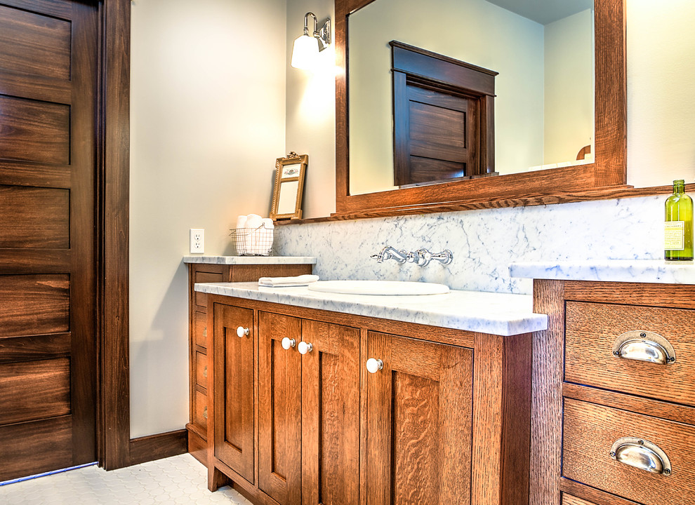 Photo of a mid-sized arts and crafts master bathroom in Other with a drop-in sink, marble benchtops, shaker cabinets, medium wood cabinets, white tile, porcelain tile, beige walls and porcelain floors.