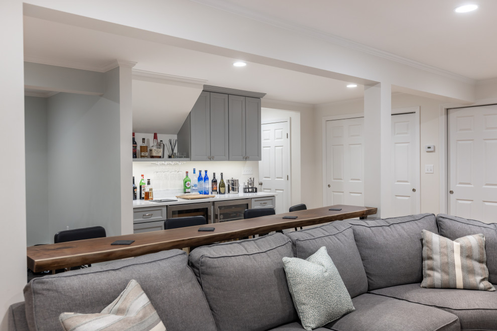 Photo of a mid-sized modern basement in Boston with a home bar, grey walls, vinyl floors, a ribbon fireplace and brown floor.