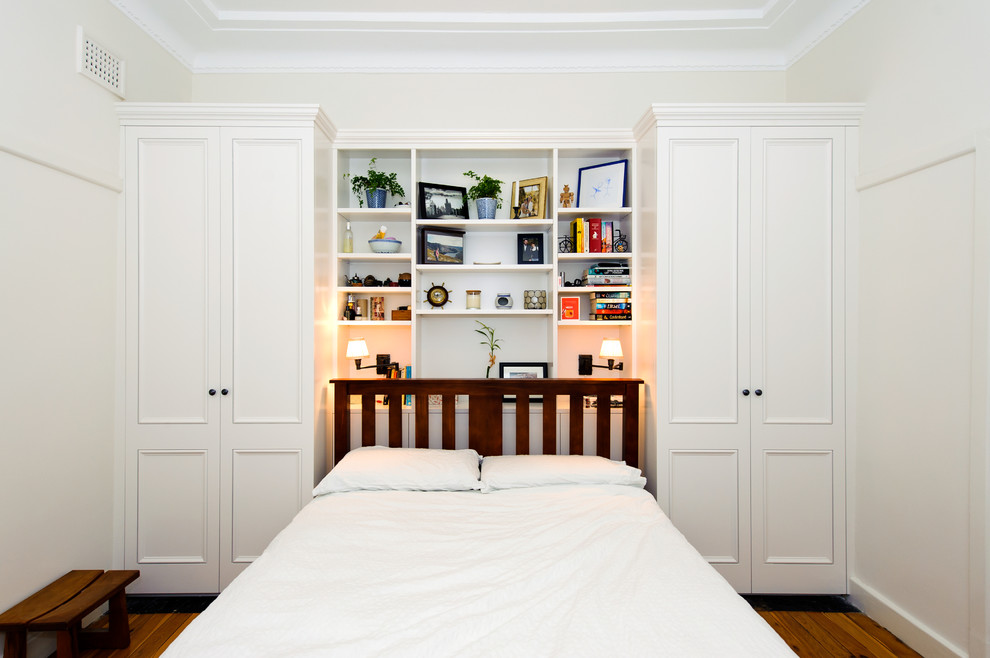 Photo of a traditional master bedroom in Sydney with white walls, light hardwood floors and brown floor.