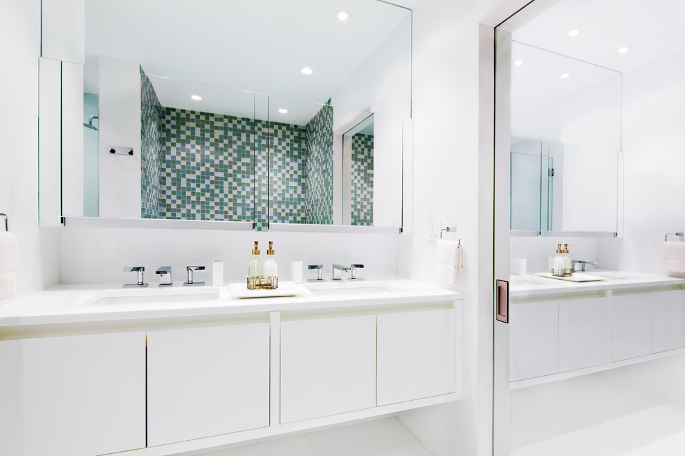 Large contemporary master bathroom in New York with an undermount sink, flat-panel cabinets, white cabinets, multi-coloured tile, mosaic tile, an alcove shower, a one-piece toilet and white walls.