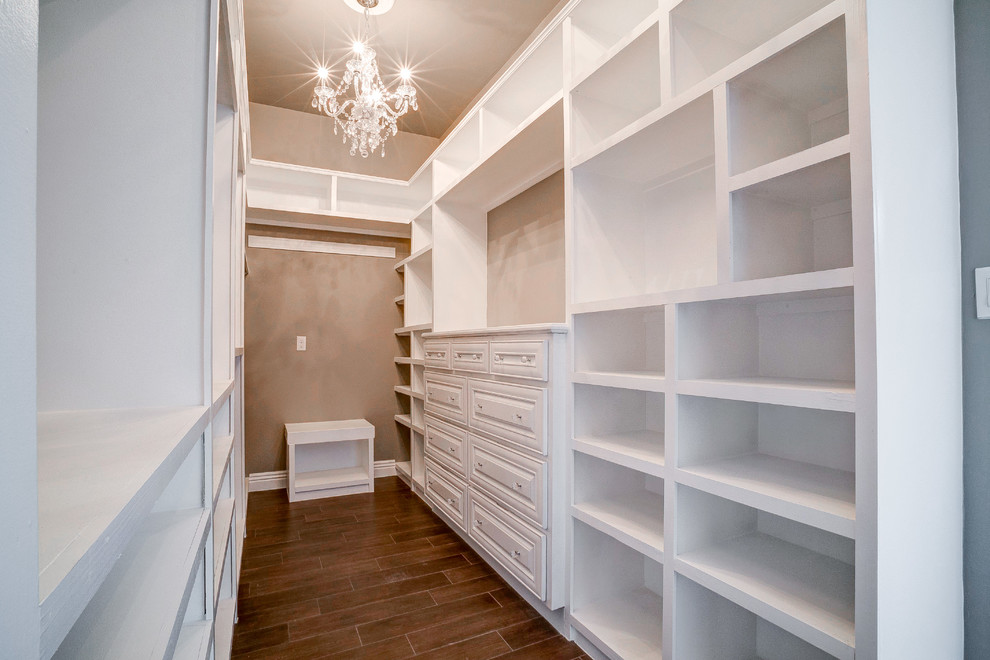 Mid-sized traditional gender-neutral walk-in wardrobe in Austin with open cabinets, white cabinets and porcelain floors.