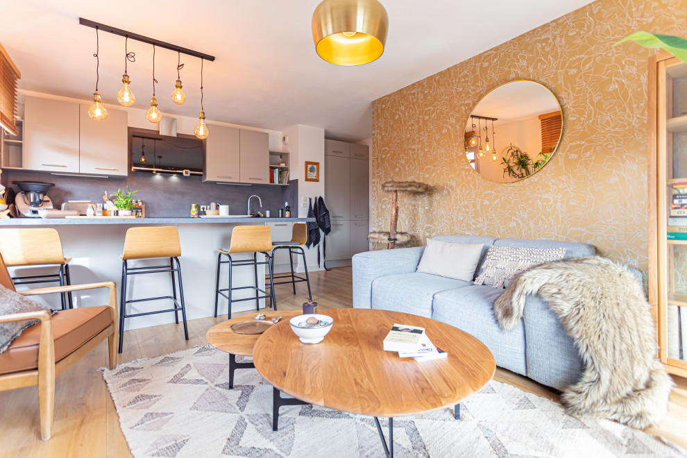 Immagine di un soggiorno design di medie dimensioni e aperto con pareti beige, parquet chiaro e carta da parati