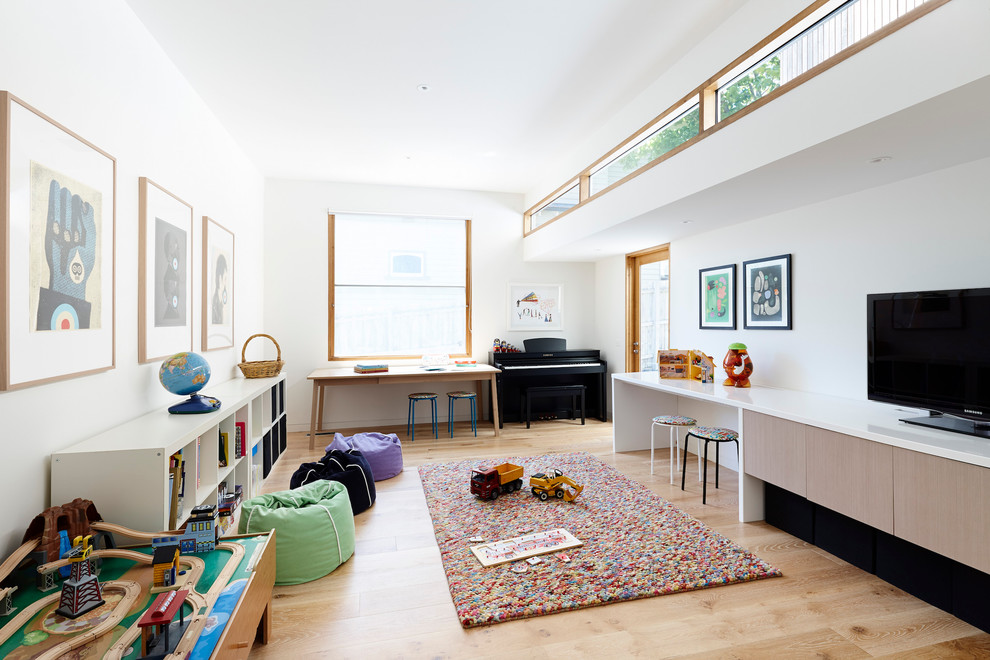 This is an example of a mid-sized contemporary gender-neutral kids' playroom for kids 4-10 years old in Melbourne with white walls and light hardwood floors.