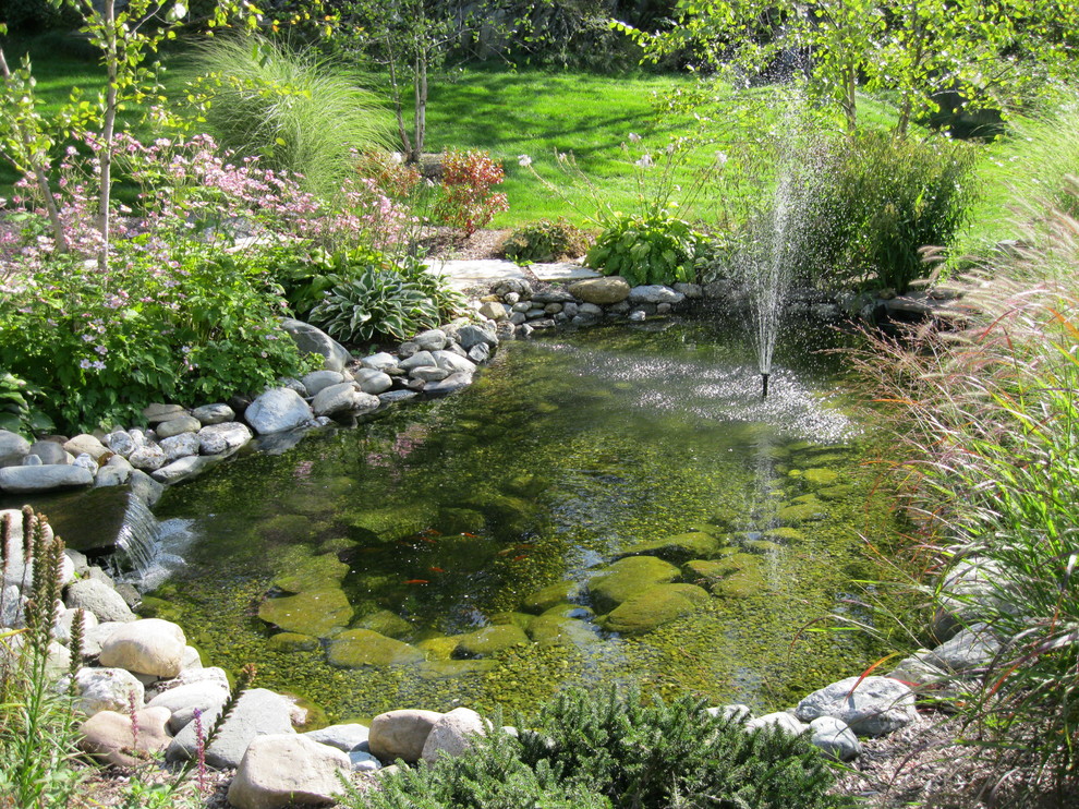 Large arts and crafts backyard partial sun garden in Burlington with with pond and gravel.