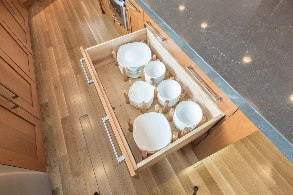 Kitchen - transitional u-shaped medium tone wood floor kitchen idea in Boston with an undermount sink, shaker cabinets, medium tone wood cabinets, quartz countertops, gray backsplash, stone slab backsplash, stainless steel appliances and an island