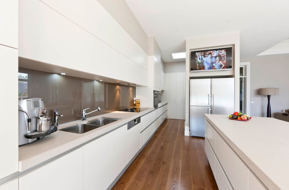 Inspiration for a large contemporary galley eat-in kitchen in Other with an undermount sink, white cabinets, quartz benchtops, grey splashback, glass sheet splashback, stainless steel appliances, dark hardwood floors and with island.